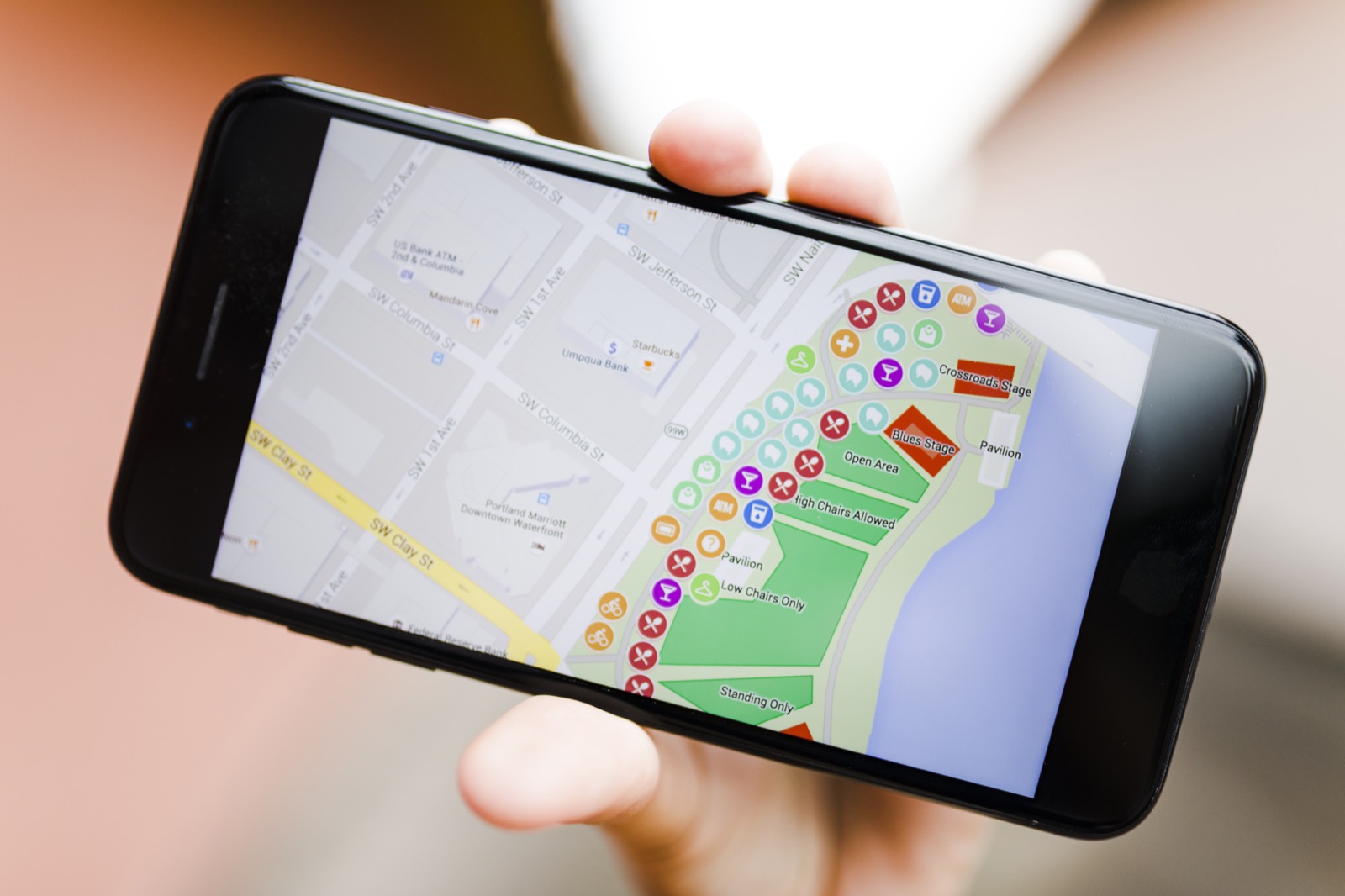 Mão segurando celular com mapa e localização aberta